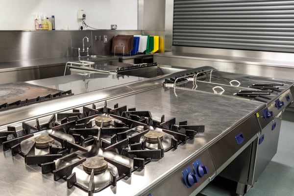 Picture of professional kitchen showing gas stove in foreground