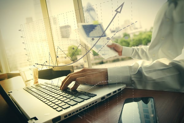 business documents on office table with smart phone and digital tablet and graph business diagram and man working in the background